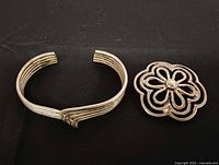 Cuff bracelet and floral brooch front view