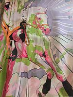 Close-up of colorful horse and tree design on scarf fabric