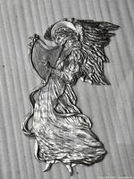 Full view of pewter angel wall hanging on foam backdrop
