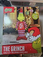 Retail box front showing The Grinch inflatable image, branding, height specification and one-piece content