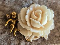 Front view showing carved white rose and gold-tone cherub