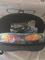 Sunglasses in open JUASHINE case with accessories in bags
