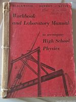 Front cover of physics workbook showing title, authors and taped spine