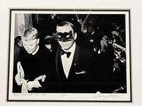 Front view of framed gelatin silver photograph showing Frank Sinatra and Mia Farrow wearing masks, signature and edition number visible