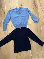 Front view of both sweaters laid flat