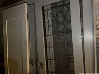 Stack of painted gray door slabs showing panel design and glass insert