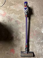 Full view of assembled Dyson V7 cordless vacuum with floor head and purple wand.