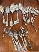 All 23 pieces arranged on table showing variety of forks and spoons