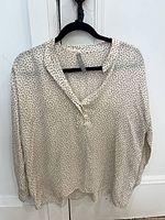 Front view of Vince polka dot blouse on hanger