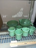 Set of five mugs and two bowls on shelf