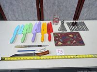 Full lot overview showing knives, flatware, trivet, carving tools, jar