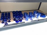 Group view of all cobalt blue glass pieces on shelf