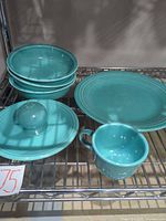 Complete set on wire shelf: three bowls stacked, dinner plate, salad plate, dome shaker, mug