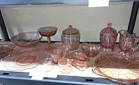 Full shelf view showing all pink Depression glass pieces grouped together