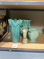 All four McCoy pieces on shelf for scale and grouping