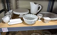 Group view of all milk glass pieces on shelf
