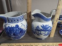 Front view of both pitchers beside rulers showing height and width