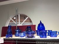 All cobalt blue glass items arranged on shelf