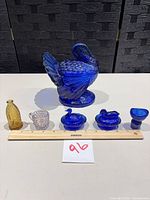 All six pressed glass items arranged with ruler for scale