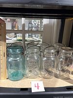 Shelf view showing all eight jars with ruler for height reference