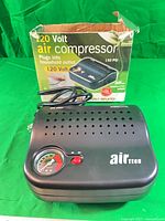 Front view of compressor showing gauge, button, power cord, and box