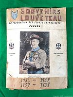 Front cover of Souvenirs de Louveteau scrapbook showing title, wolf emblem and handwritten 1956-1958 dates