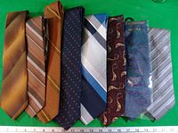 Eight assorted neckties laid flat side-by-side