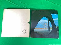 Book in dust jacket beside slipcase front view