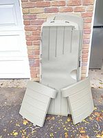 Disassembled panels of Rubbermaid deck box leaning against wall