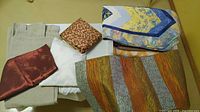 Group of folded fabrics on table showing main colours and textures