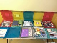 Overall view of 10 latch cases open showing assorted craft contents