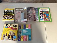 Six quilting and sewing books laid out on a table showing titles and covers