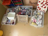 Three clear totes of thread spools, wooden thread rack, multicolour drawer tower visible
