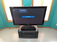 Front view of TV on stand showing display powered on