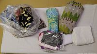 Bundle of assorted fabric pieces and remnants in plastic bag and folded stacks