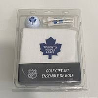 Front view of sealed golf gift set showing towel, ball, tees and NHL branding