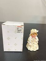 Box with price label alongside snowman figurine front view