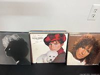 Three LPs standing: silhouette cover (likely Memories), Songbird, close-up portrait cover