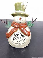 Front view of ceramic snowman tealight holder showing snowflake cutout and overall design