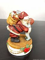 Front view Santa hugging child on decorated base