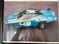 Full view of framed photographic print showing blue Plymouth No. 43 race car