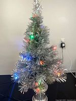 Full view of silver tinsel tree illuminated