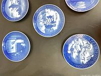 Group of four blue porcelain plates with winter scenes