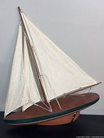 full view left side of wooden sailboat model with sails set
