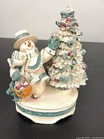 Front view of snowman figurine with tree on base