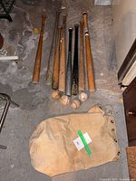Lot overview of bats, balls, bag on floor