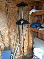 Full view of pole-mounted bird feeder inside shed