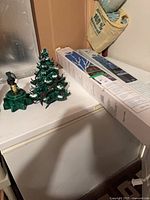 Lot overview showing ceramic tree, base, and boxed outdoor lights on surface