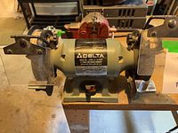 Front view of Delta bench grinder showing wheels, eye shields, tool rests, base switch