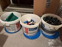 Three pails: left shows LEGO pieces; centre and right show marbles